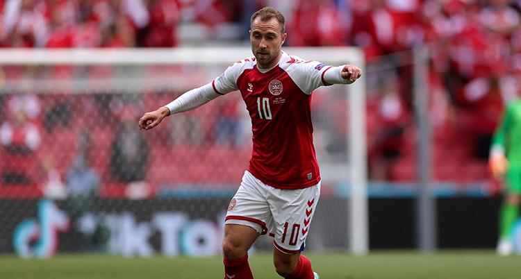 Dansken Christian Eriksen sträcker ut med armarna i en match i fotboll.