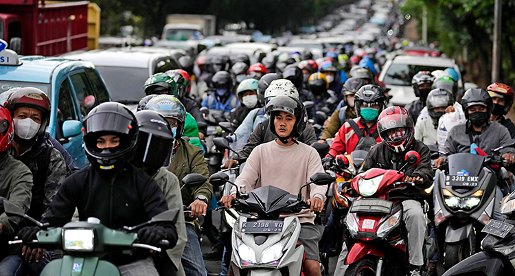 En massa bilar och mopeder står still på en väg. Det är trafikstockning i Jakarta.
