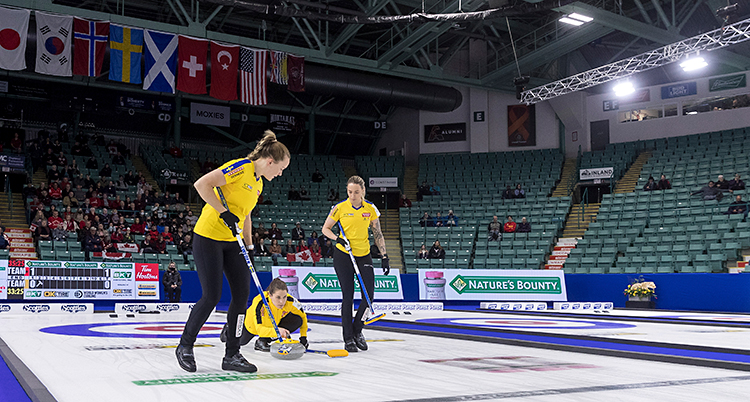 Från en match i curling. Anna Hasselborg är precis på väg att släppa en sten.