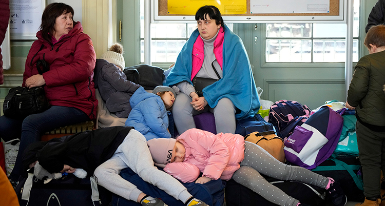 Barnen lutar sig mot kvinnorna som sitter på en bänk.