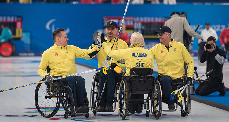 Svenska laget firar och ger varandra high five.