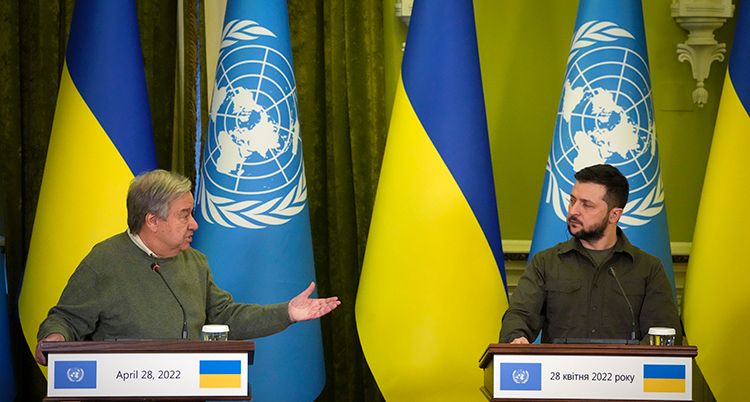 De står i varsin talarstol. Guterres till vänster tittar på Zelenskyj till höger. Guterres sträcker ut sin hand.