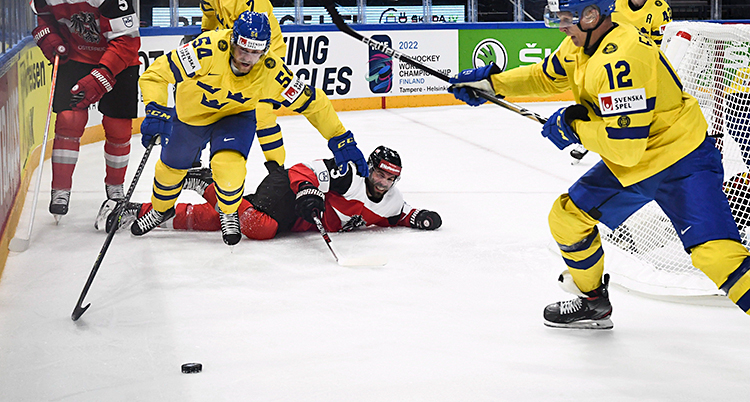 Från en match i ishockey. Flera spelare kämpar om pucken.