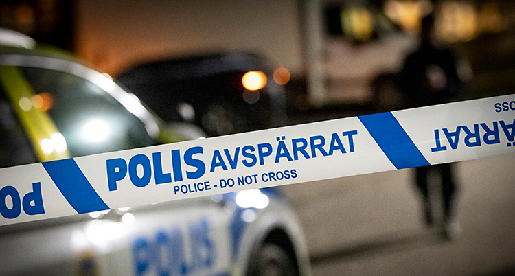 Det är kväll. Poliserna har spärrat av med ett blått och vitt band.