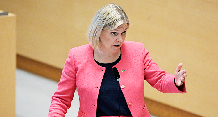 Magdalena Andersson står och pratar i talarstolen i riksdagen.