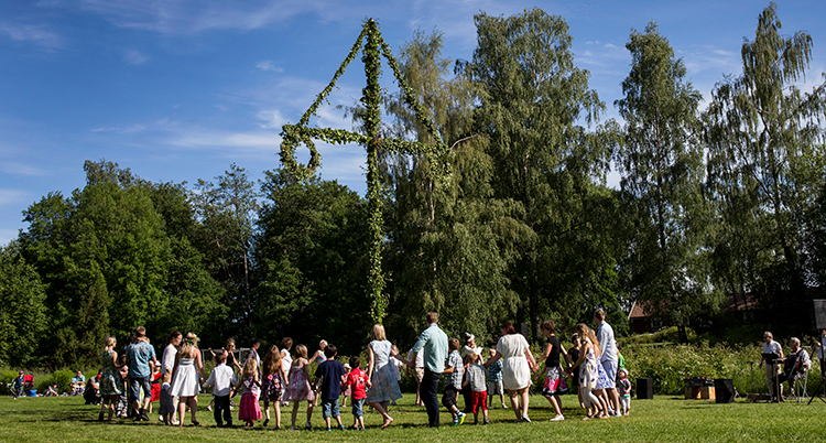 Folk dansar i ring runt en stång.