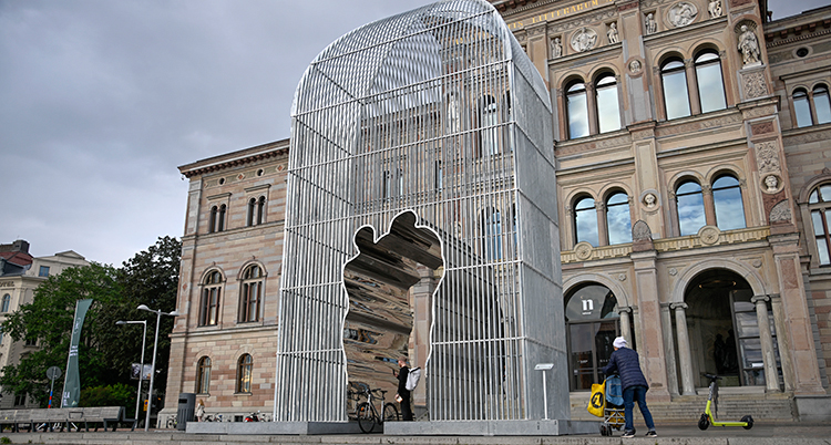 En stålskulptur står framför en stor gammal byggnad