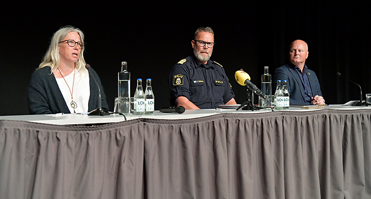 Tre personer sitter vid ett bord och har en träff för journalister.