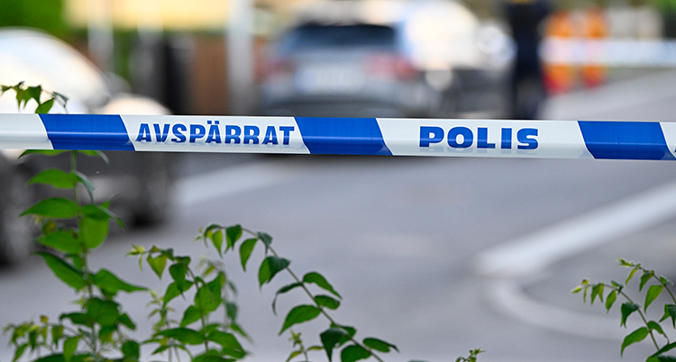 En avspärrning med polisband. Bakom syns en gata.