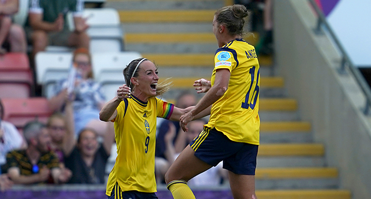 Från en match i fotboll. Två svenska spelare tittar på varandra och jublar.