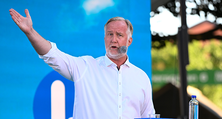 Pehrsson talar och sträcker ut armen.