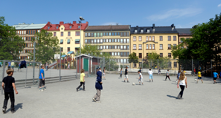 barn på en skolgård spelar fotboll.