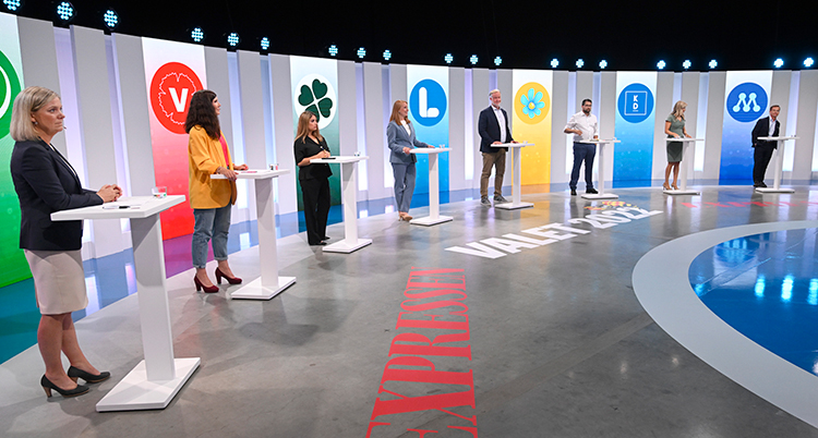 Partiernas ledare står bredvid varandra vid varsitt litet bord.