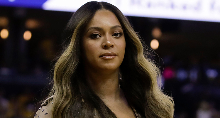 Artisten Beyoncé tittar in i kameran. Hon har långt ljust och mörkt hår.