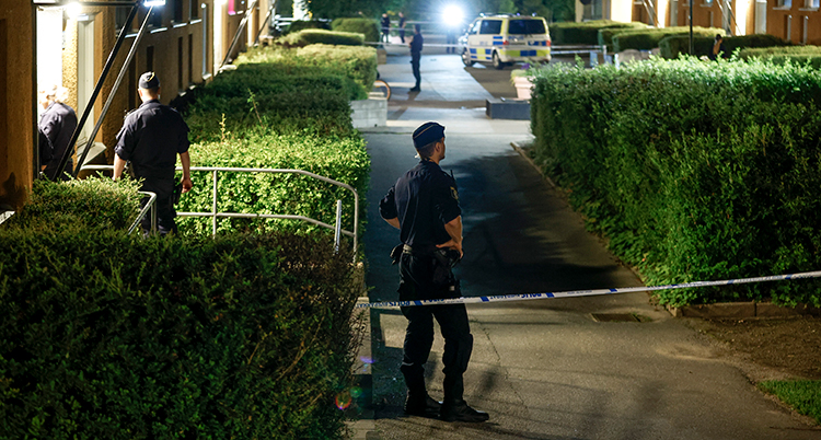 Poliser utanför ett hus på natten.