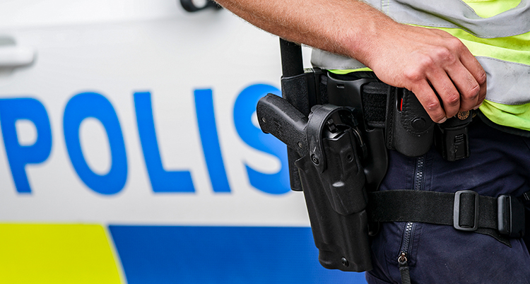 En polisbil och en polis ben med en pistol.