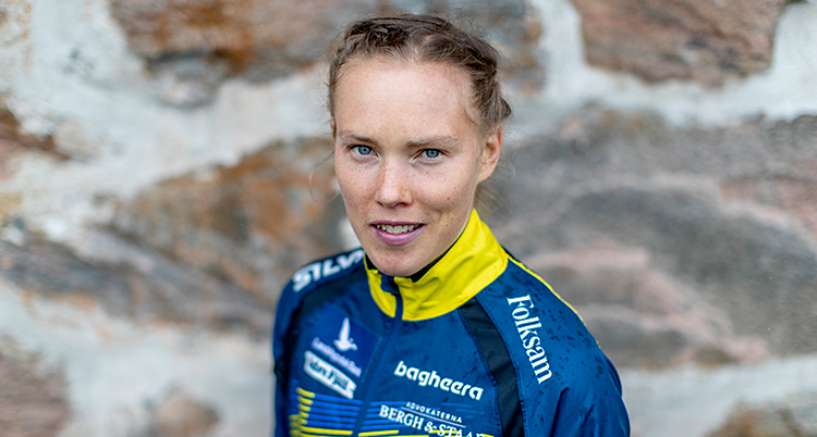 Hon ler och tittar in i kameran.