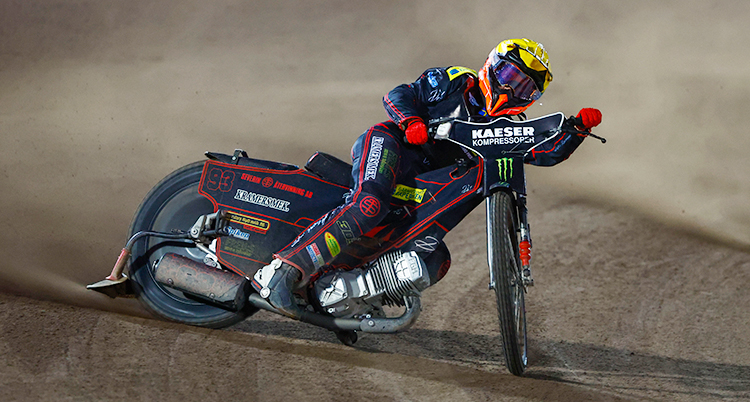 En speedwayförare sladdar med sin motorcykel.