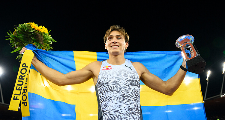 Duplantis håller upp en svensk flagga.