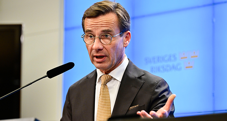 Ulf Kristersson pratar i en mikrofon på en presskonferens.