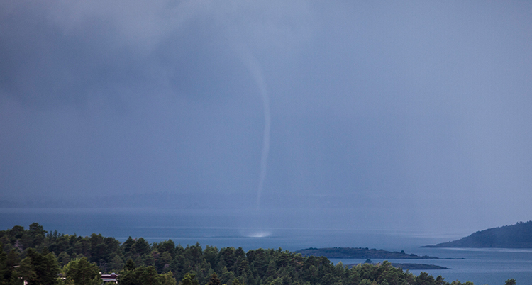 En tromb syns över havet som en pelare mellan himlenoch vattenytan