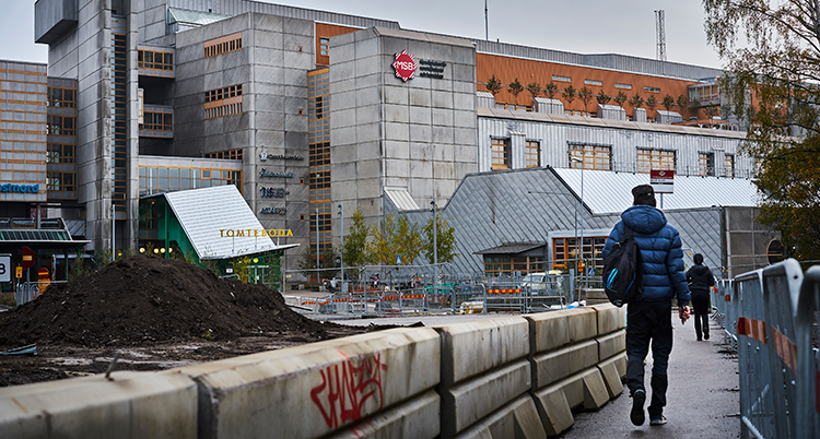 En ung person går mot en byggnad