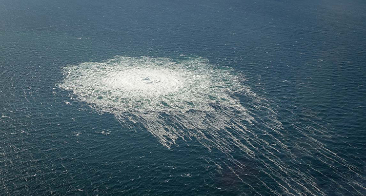 En bild som är tagen från luften, ner mot havet. Där bubblar det upp gas på ytan.