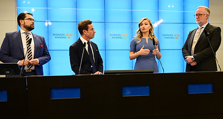 De fyra ledarna står bredvid varandra och pratar till journalister.