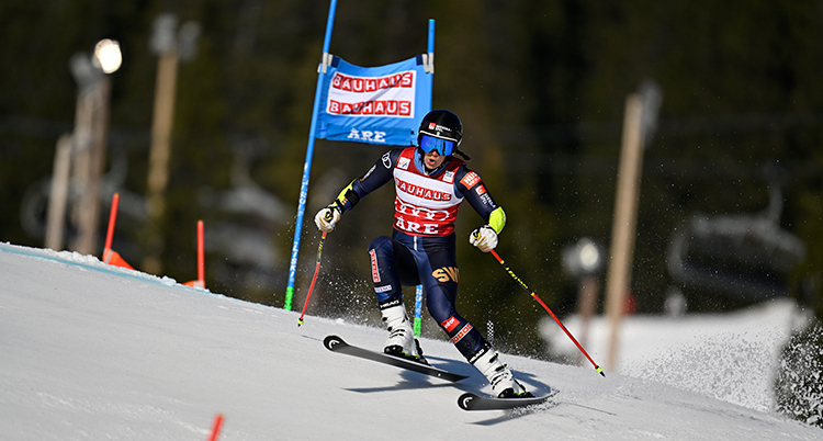 En kvinna på skidor åker storslalom.