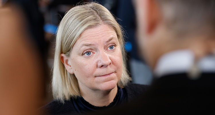 Hon tittar på en person som står framför. Hon ser allvarlig ut.