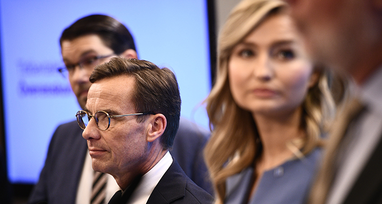 Nära tagen bild på Åkesson, Kristersson och Busch.