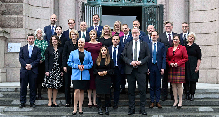 Alla nya ministrar uppställda ute på en trappa framför ett hus.