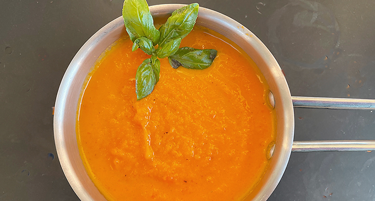 En kastrull med orange soppa.