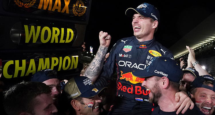 Verstappen skrattar och lyftas upp.