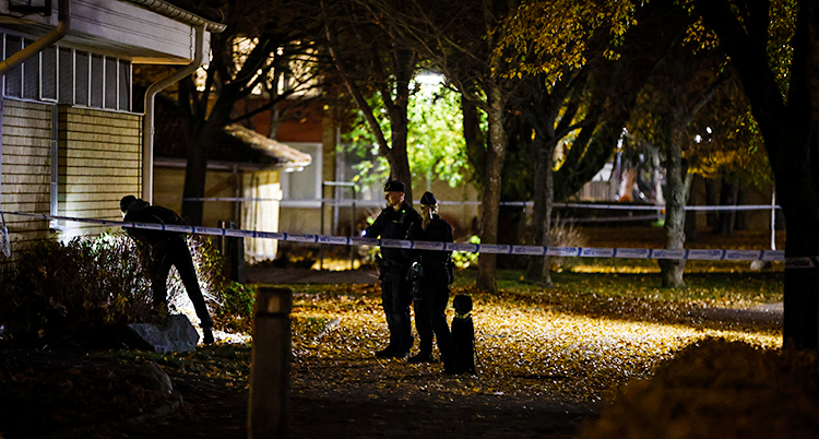 Det är mörkt ute. Tre poliser undersöker vid ett hus.