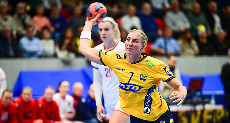 Hon skjuter ett skott i en match i handboll.