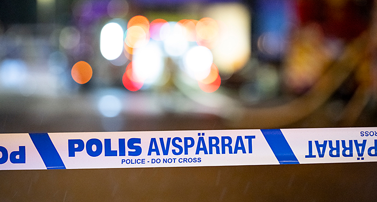 Poliser har spärrat av med ett band som är vitt och blått.