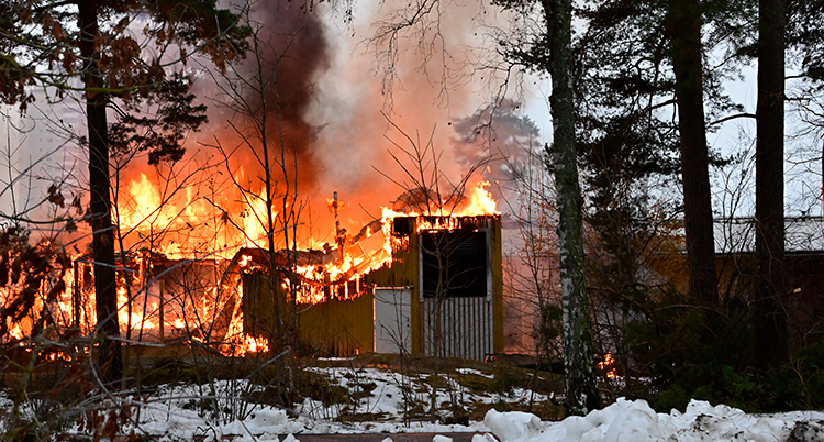 Lågor i en röd byggnad.