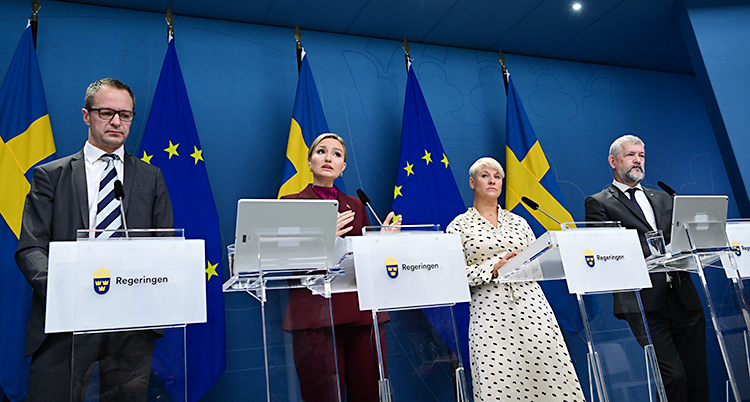 Fyra personer står bredvid varandra och pratar på en träff med journalister.