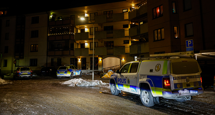 En polisbil står utanför ett hus.