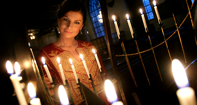 Carola framför levande ljus.