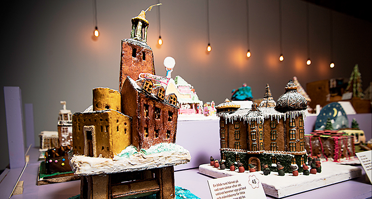 Flera pepparkakshus på ett bord. Husen närmast är bland annat stadshuset på flera pålar över vattnet.