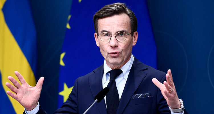 Kristersson talar och håller upp händerna.