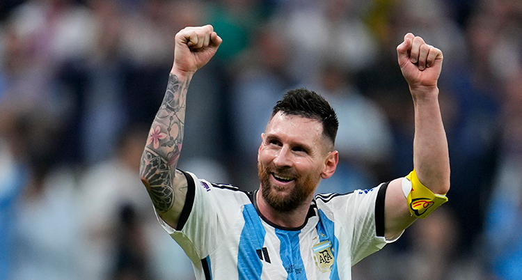Han sträcker upp armarna i luften. Han har Argentinas blå och vita tröja på sig.