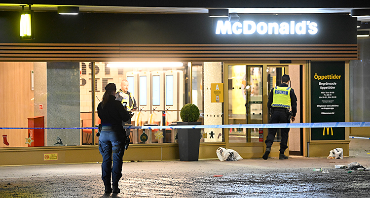 Det är mörkt. Några poliser är vid ett McDonald's.