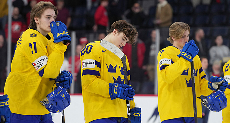 Tre hockeyspelare står på isen, efter matchen.