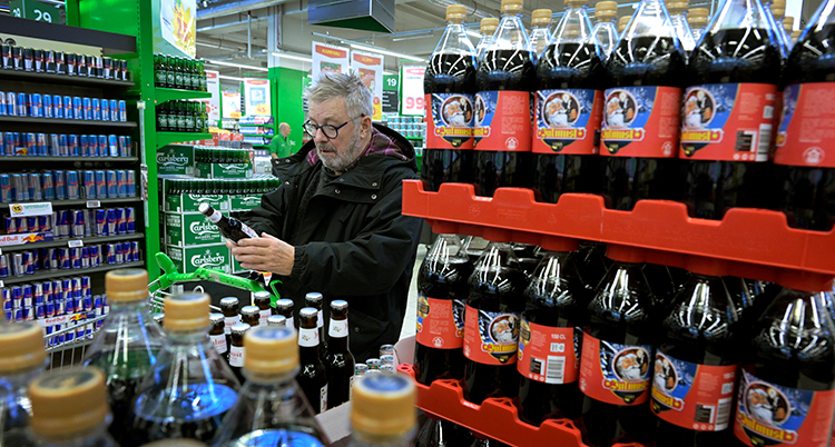 En man i en affär bland en massa läsk.