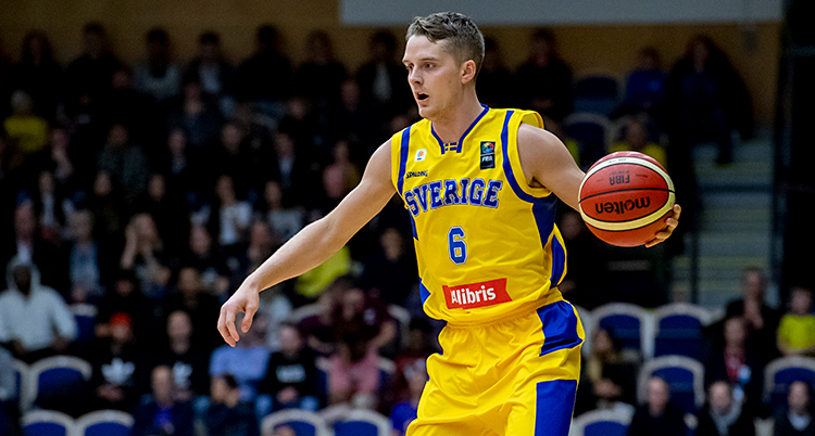 Han håller i en basketboll under en match.