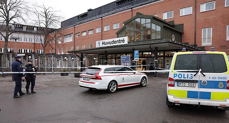 Poliser jobbar utanför ingången till sjukhuset.