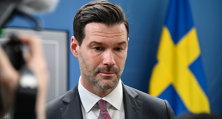 Ett porträtt. Bakom syns en svensk flagga. Till vänster syns en filmkamera.